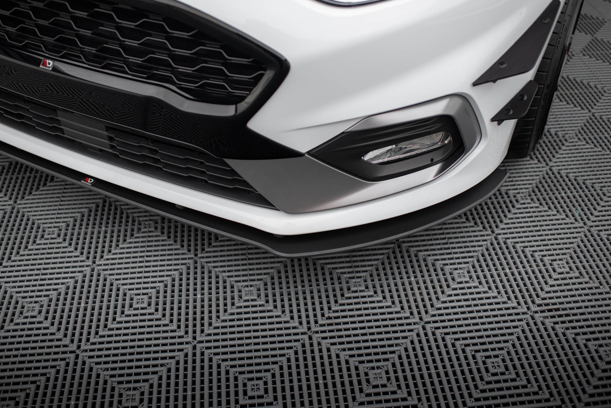 Front splitter på Ford Fiesta MK8 ST med sort grill, tåkelys og kontrasterende svarte detaljer.