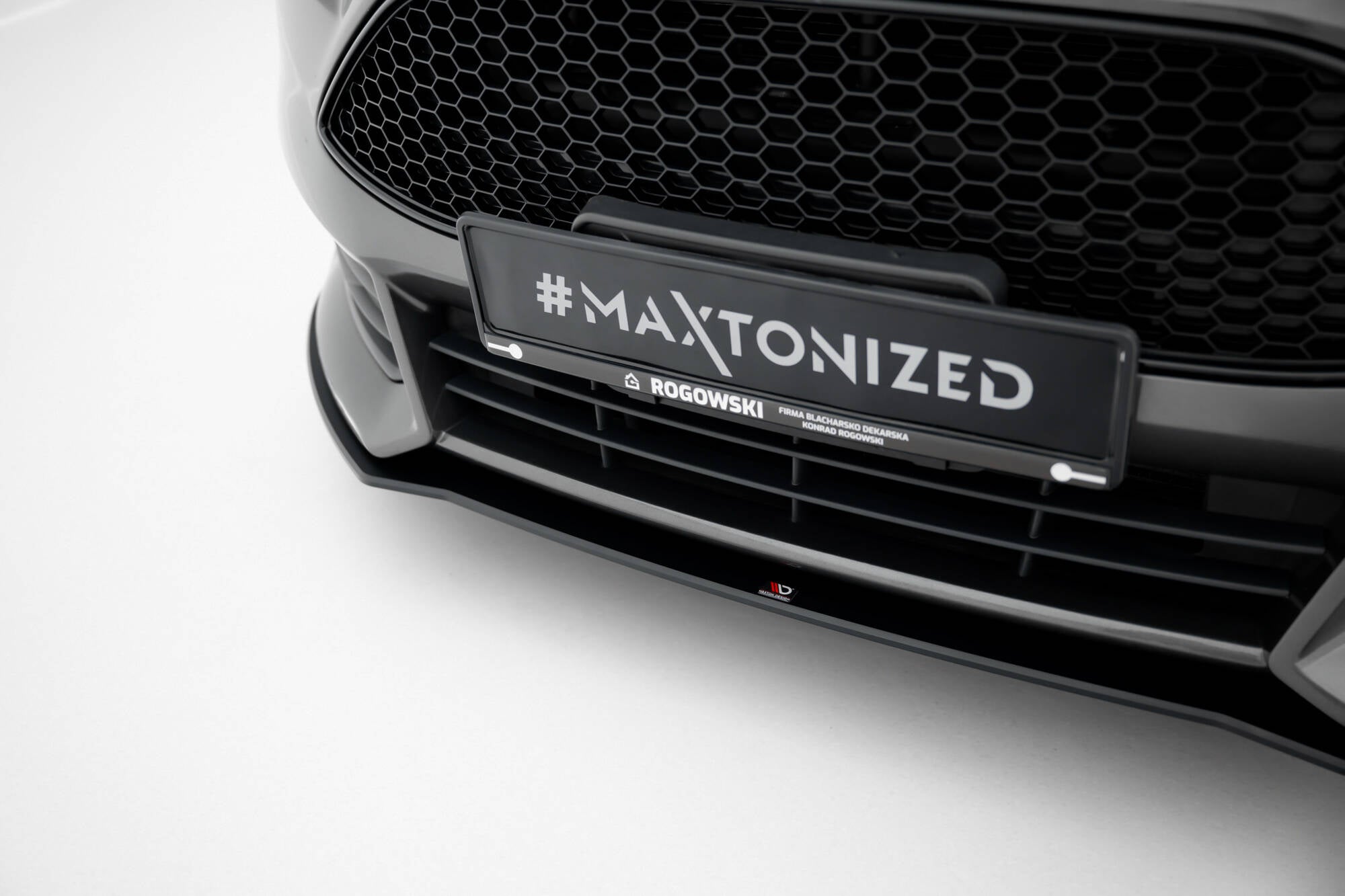 Spoiler til Ford Focus ST MK3 Facelift V2, sort med bikubemønstret grill og skiltet #MAXTONIZED.