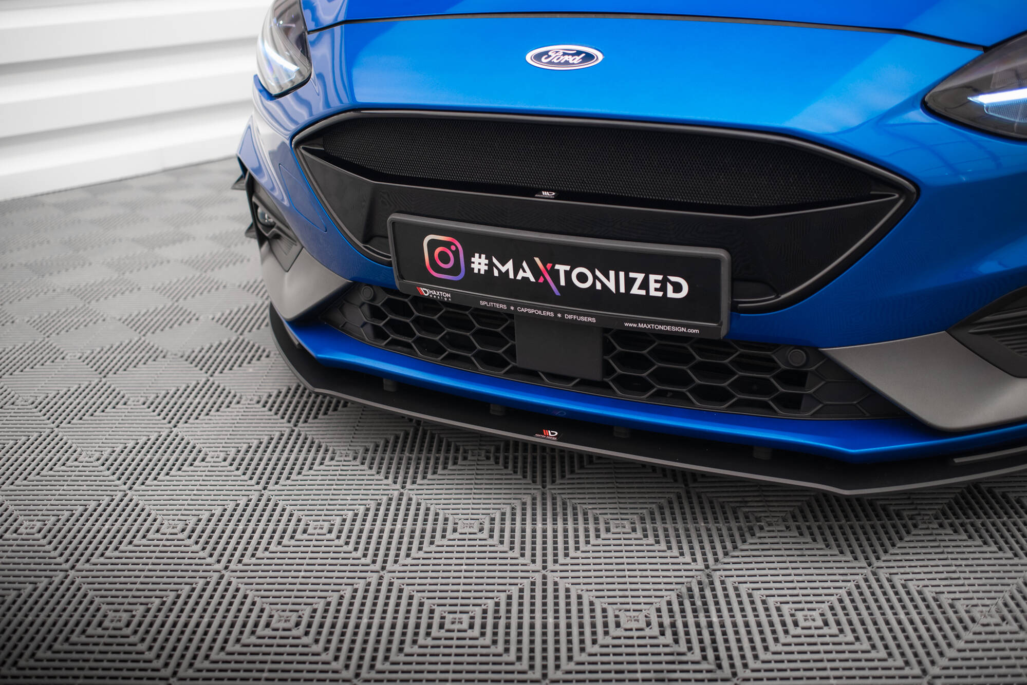 Spoiler til Ford Focus MK4 ST med sort grill og #MAXTONIZED-skilt, sett fra lav vinkel.
