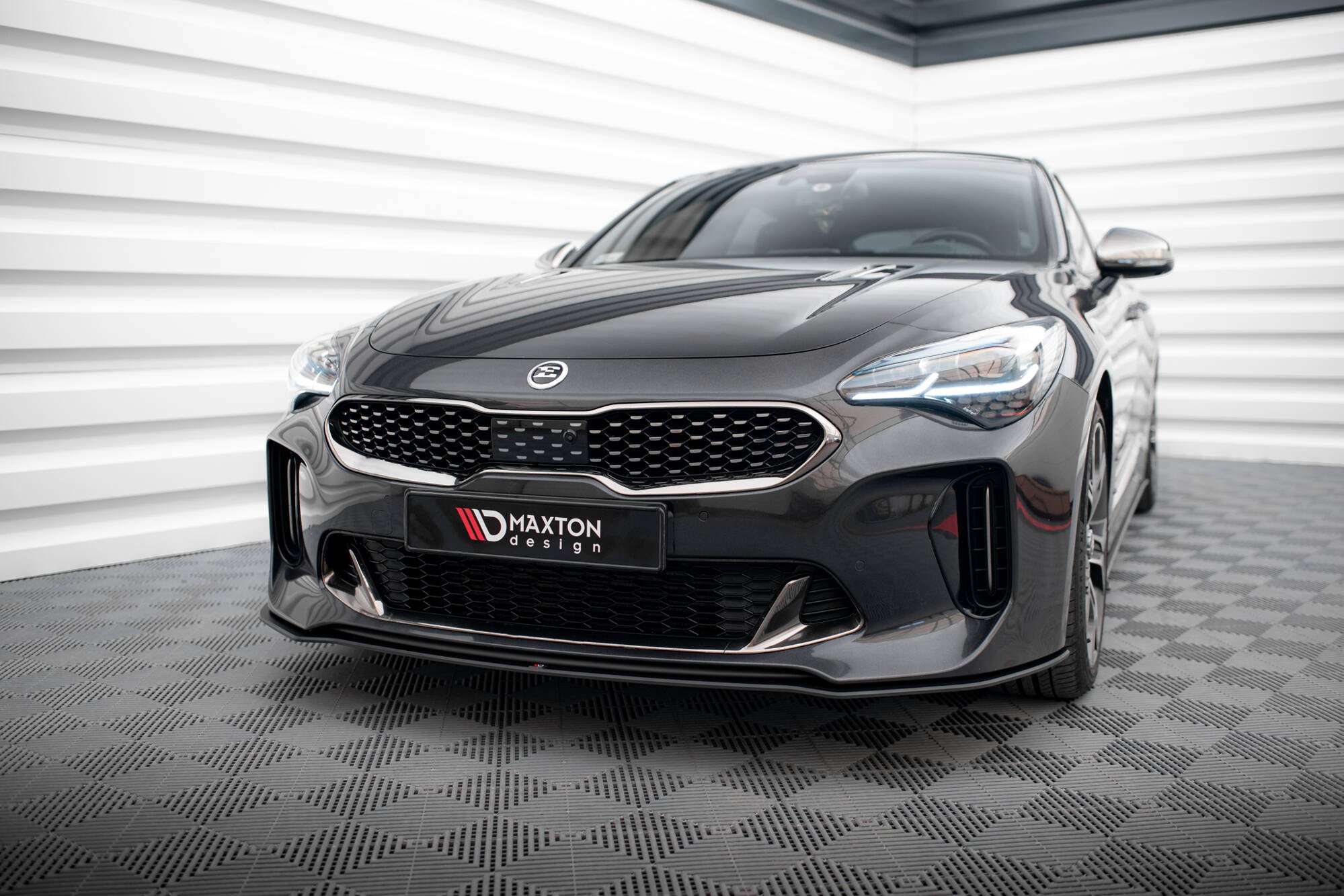 Frontspoiler til Kia Stinger GT MK1 2017-2023 på mørk grå bil med LED-lykter og sportslig støtfanger.