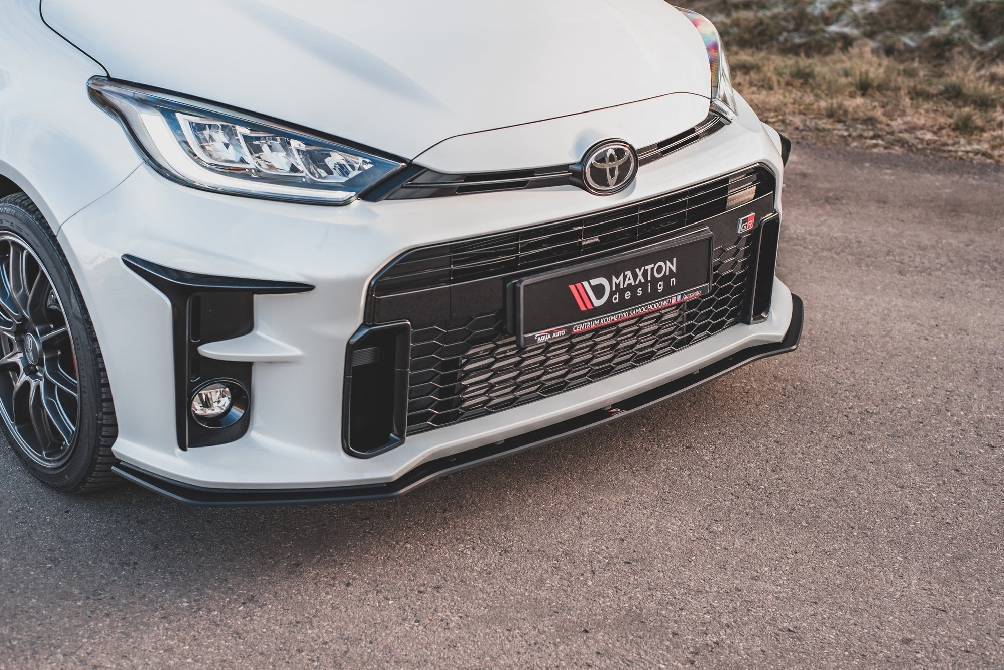 Frontleppe på Toyota GR Yaris MK4 i hvitt med svart grill og sportsfelger, sett fra skrå vinkel.