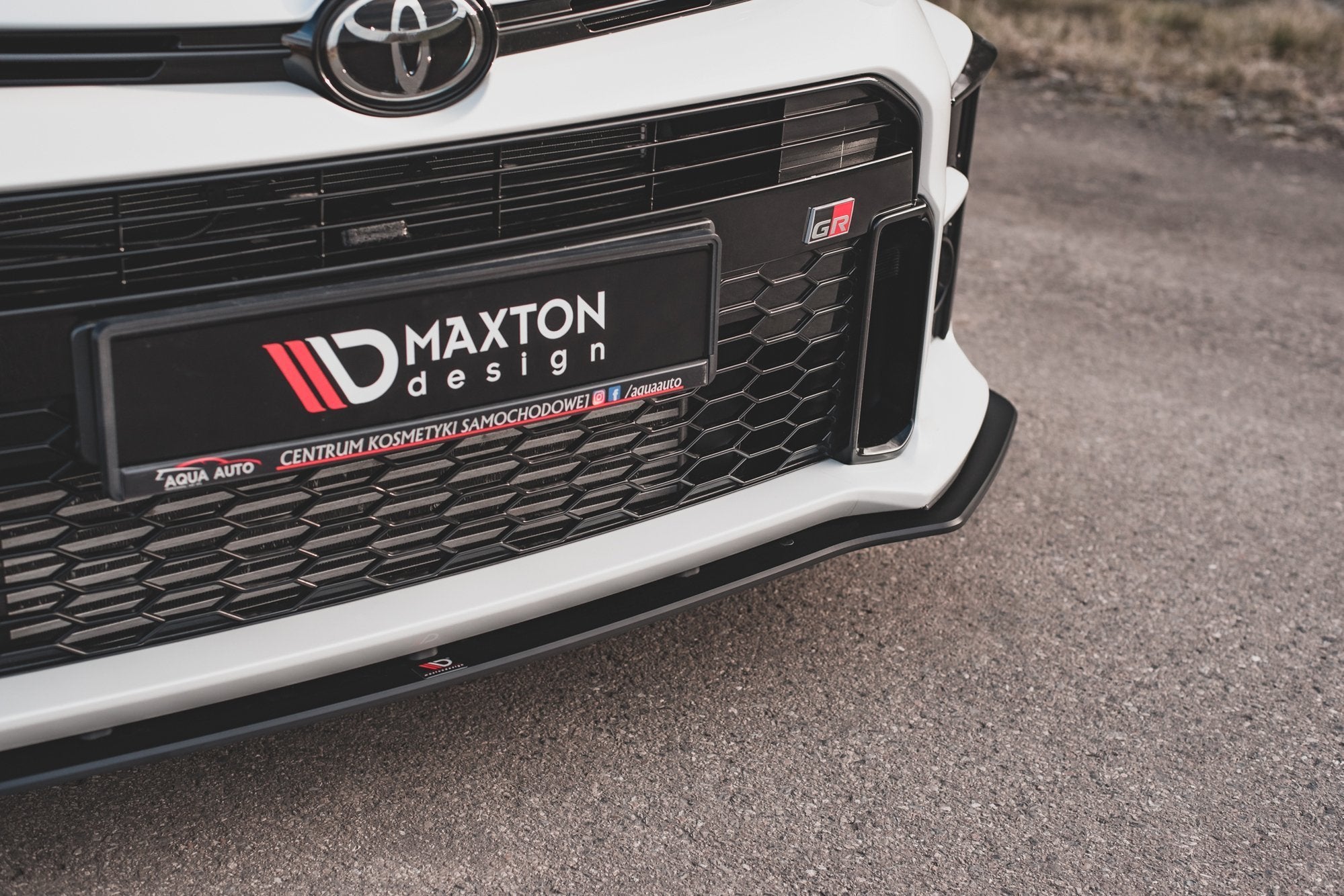 Spoiler til Toyota GR Yaris MK4 i ABS, nærbilde av frontfanger med sort grill og Maxton Design-logo.