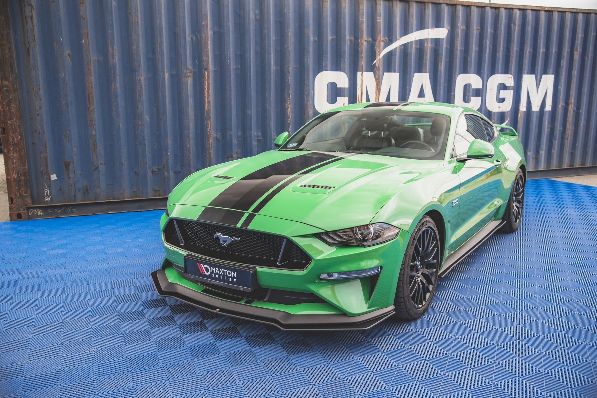 Frontspoiler på grønn Ford Mustang GT MK6 Facelift med svarte striper, fotografert skrått forfra.