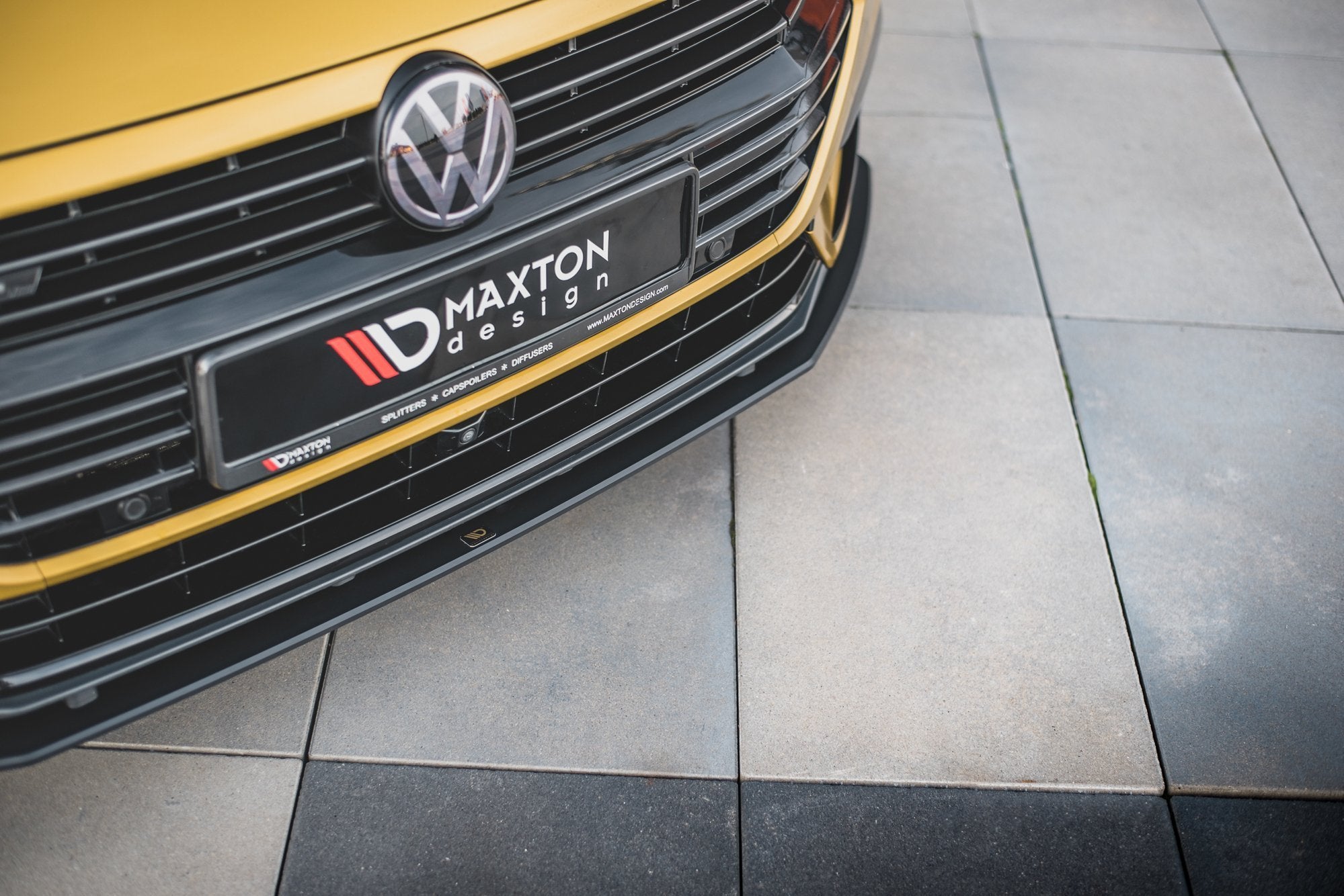 Spoiler på VW Arteon R-Line i gul med sort frontspoiler, synlig grill, logo og Maxton Design-skilt.