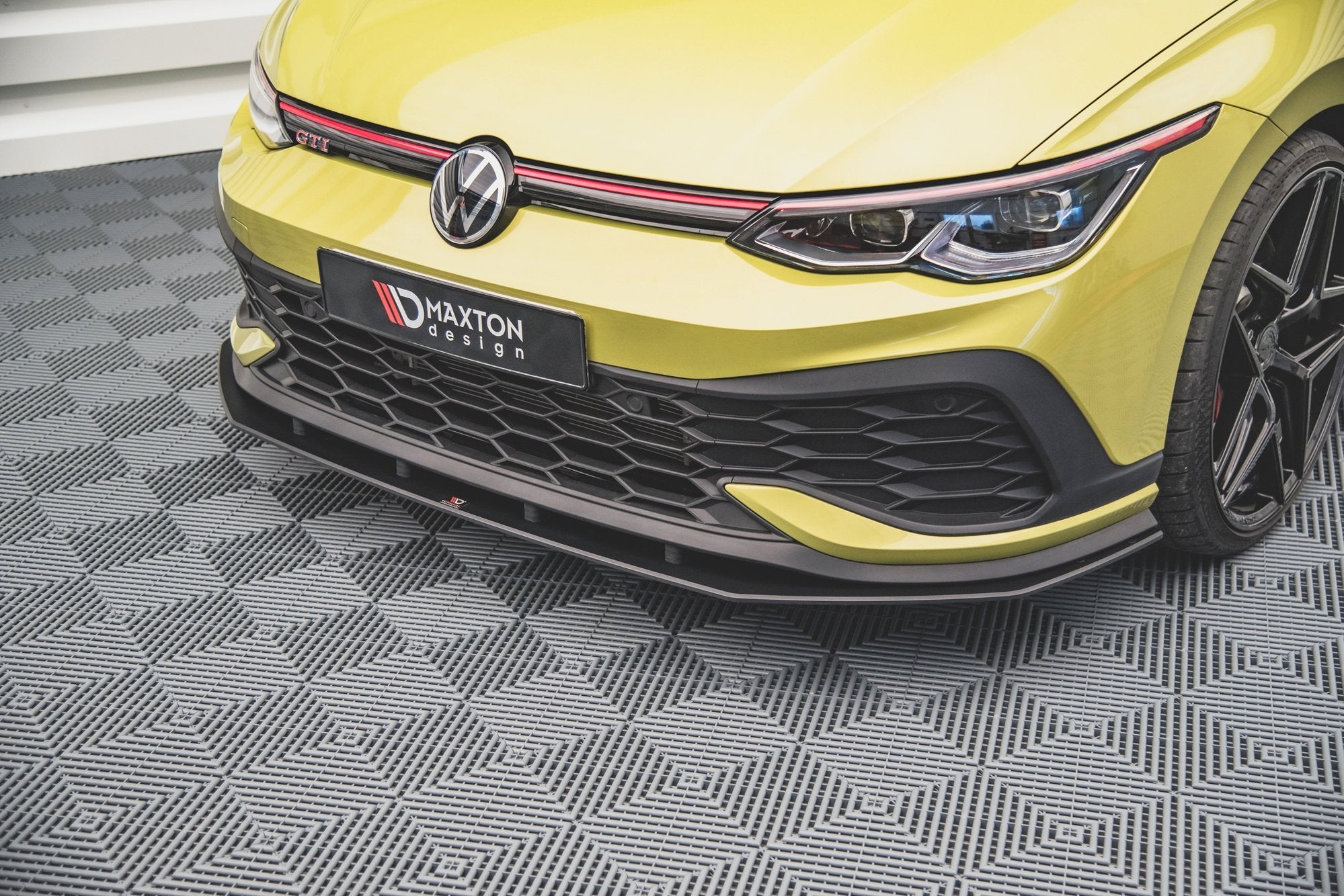Frontspoiler til VW Golf GTI Clubsport MK8 i matt svart, montert på lysegul bil med røde detaljer.