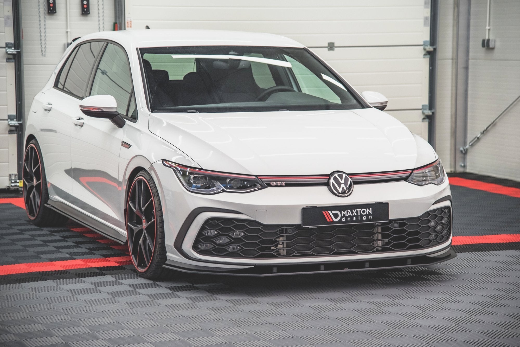 Frontspoiler på VW Golf GTI MK8 med sorte og røde detaljer, store felger og sportslig design.