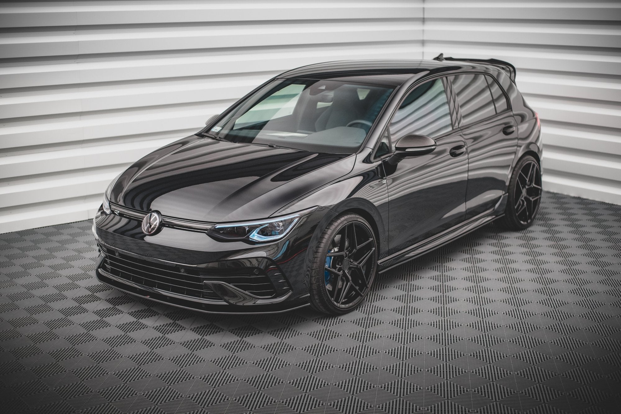 Spoiler på VW Golf R MK8 med sorte felger, blå bremsekalipere og LED-frontlykter.