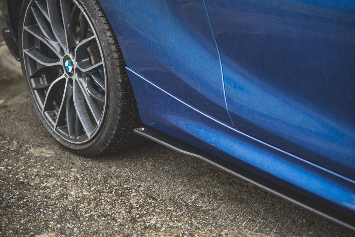 BMW 1 F21 M135i sideskjørt 10mm i matt sort plassert langs terskelpartiet på hvit karosseri