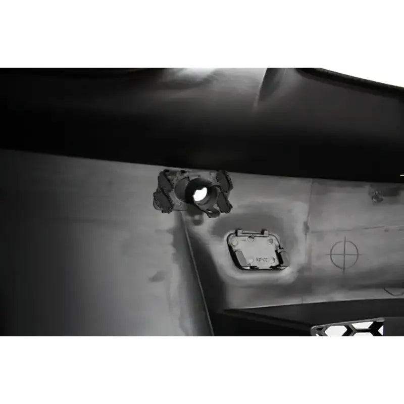 Frontbumper innsiden av sort støtfanger til BMW 1 Serie E88 med rundt hull og rektangulær luke.