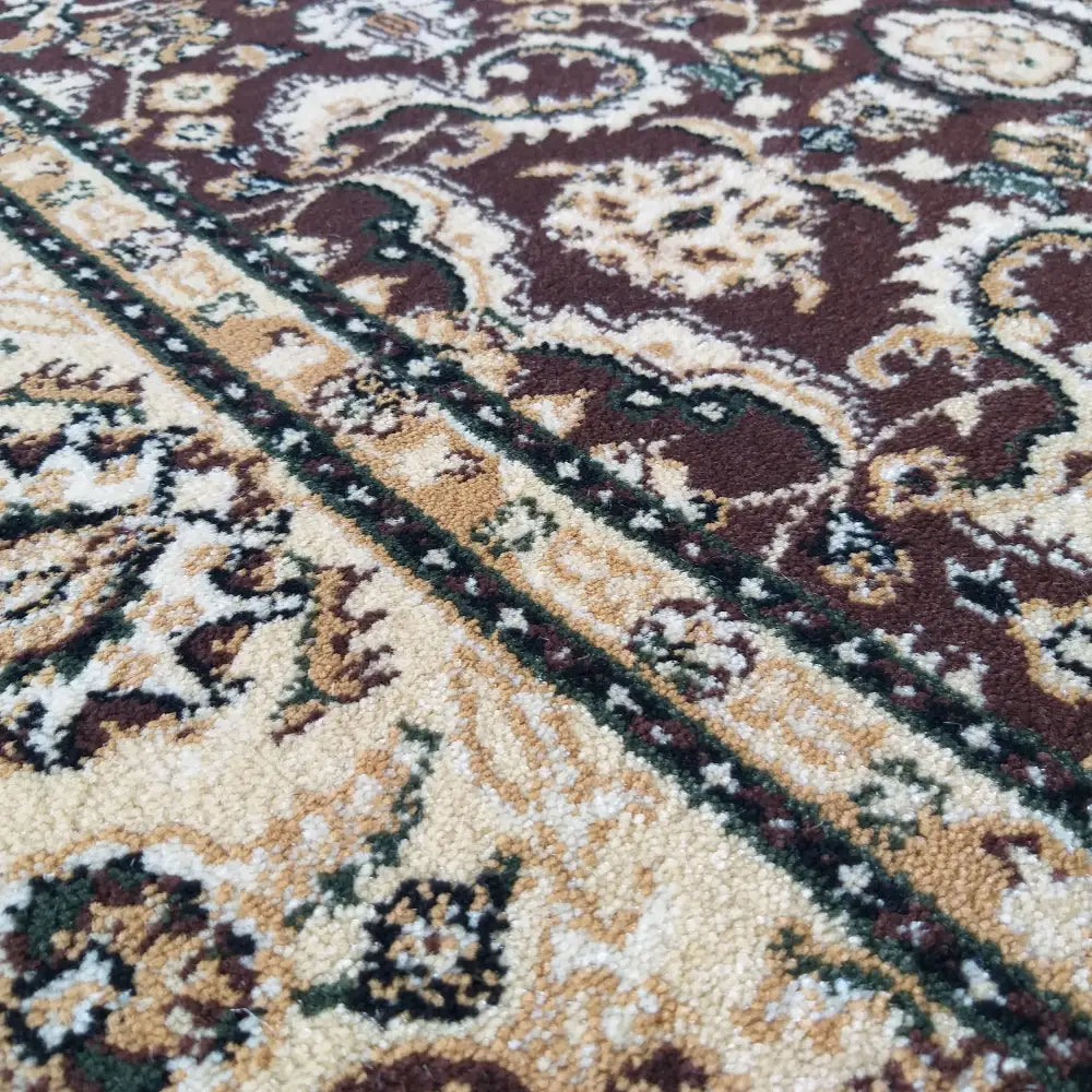 Tepe Eksklusiv teppe, nærbilde av orientalsk mønster i brunt med synlige fibre og detaljerte strukturer.