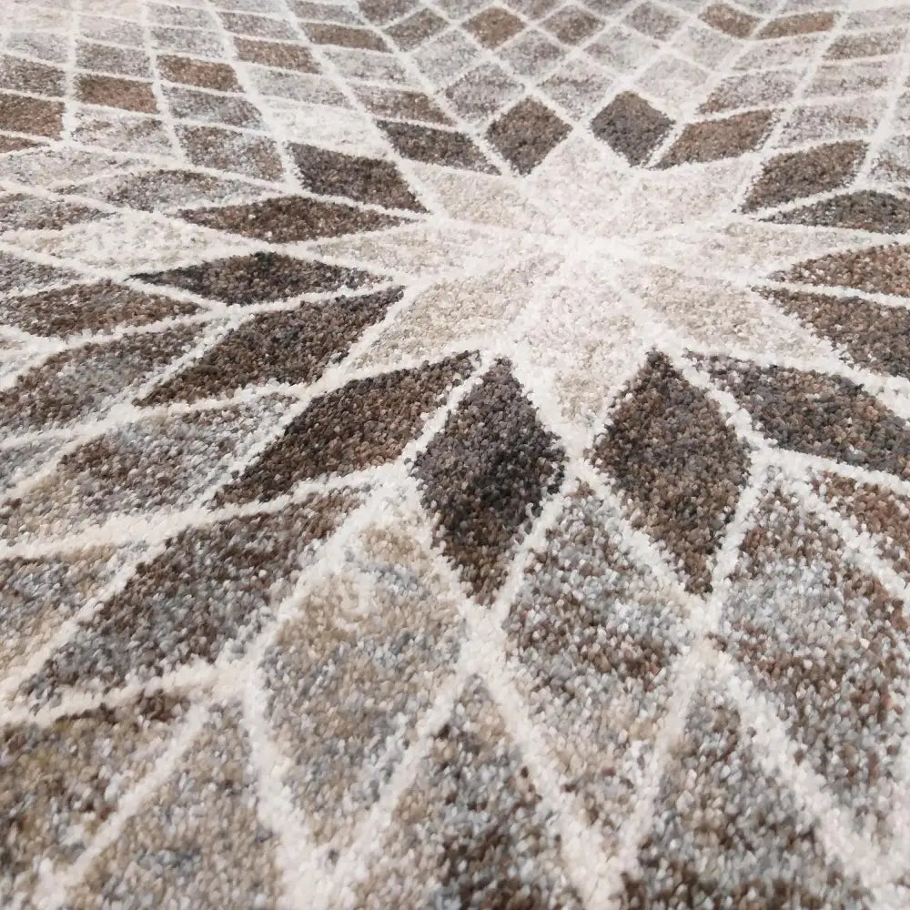 Tepe Moderne Panamero 10 teppe, nærbilde av geometrisk mønster og løvemotiv i beige, brunt og hvitt.